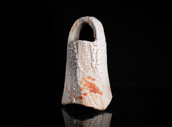 Ceramic vase with textured surface on a black background
