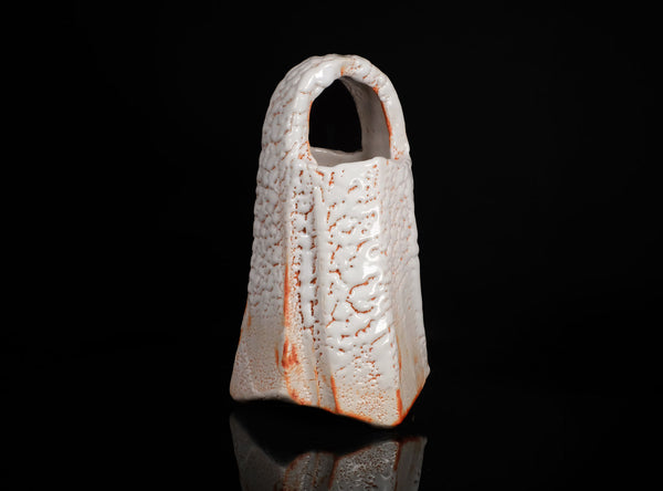 Ceramic vase with textured surface on a black background