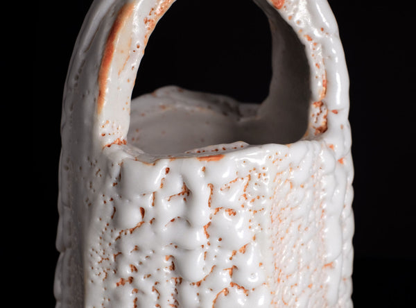 Close-up of a textured ceramic vase with a dark background