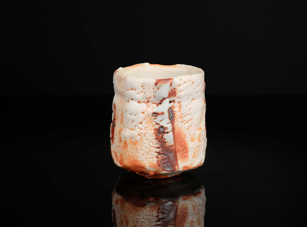 Ceramic cup with textured surface on a black background