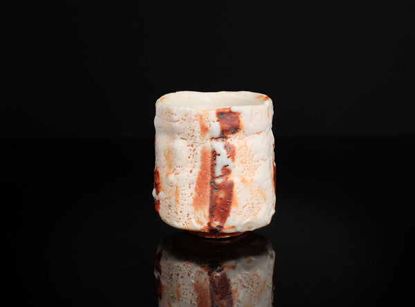 Ceramic cup with textured surface on a black background