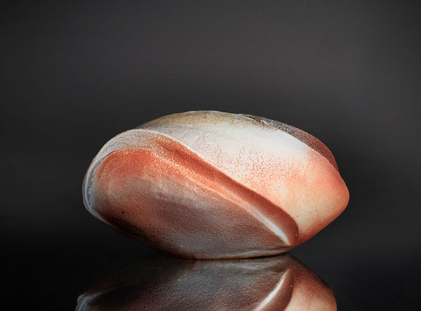 Polished vase with pink and white stripes on a reflective surface