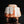 Load image into Gallery viewer, A sculptural ceramic vessel with a textured, ribbed surface, featuring a white glaze with orange and reddish-brown marbled accents, set against a solid black background with a reflective surface below.
