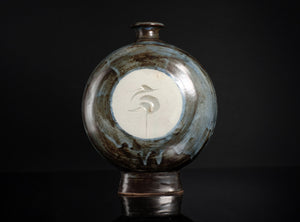 Ceramic vase with a decorative design on a black background