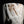 Load image into Gallery viewer, Close-up of a textured ceramic or stone object with brown and black markings on a black background
