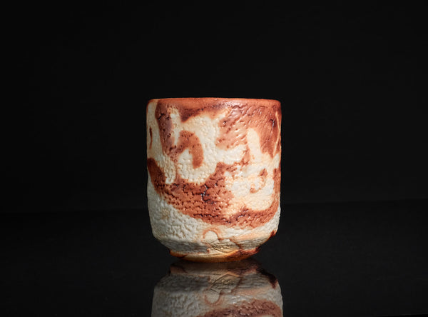 Ceramic cup with marbled design on a black background