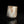 Load image into Gallery viewer, A small cylindrical stone or ceramic vessel with a rough, weathered finish in off-white and brown tones, photographed on a black reflective surface against a black background.
