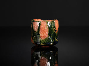 Ceramic cup with multicolored glaze on a black background