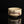 Load image into Gallery viewer, A handmade ceramic matcha bowl with a textured cream glaze and dark brown brushstroke patterns, displayed on a reflective black surface against a solid black background.
