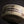 Load image into Gallery viewer, A close-up of a handmade ceramic bowl with a textured off-white glaze and dark brown painted brushstrokes, set against a dark background.

