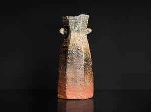 Small ceramic vase with a textured surface on a black background