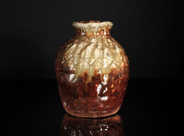 Decorative glass vase with a textured surface on a black background
