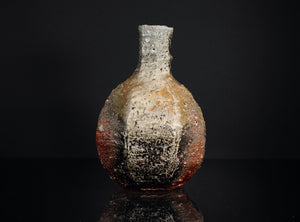 Ceramic bottle with textured surface on a black background