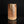 Load image into Gallery viewer, A handmade ceramic vase with a textured, geometric, faceted design in earthy terracotta and beige tones, standing on a reflective black surface against a solid black background.
