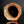 Load image into Gallery viewer, A close-up of a hexagonal ceramic tile or tile fragment with a rustic, textured brown and orange-brown glaze, set against a dark reflective background.
