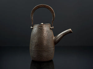 Vintage-style metal teapot on a dark background