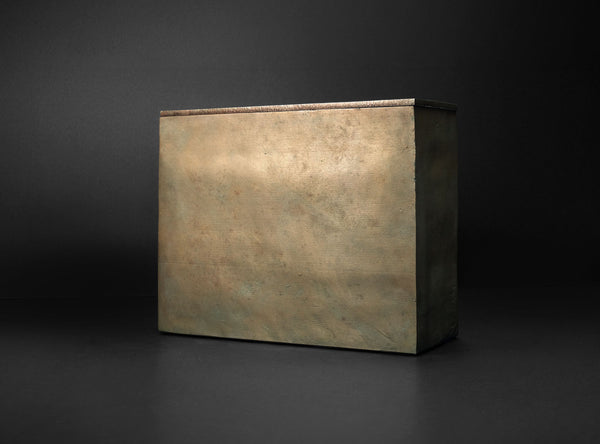 A rectangular metal box with a textured, metallic bronze finish, shown from a three-quarters perspective against a dark studio background.
