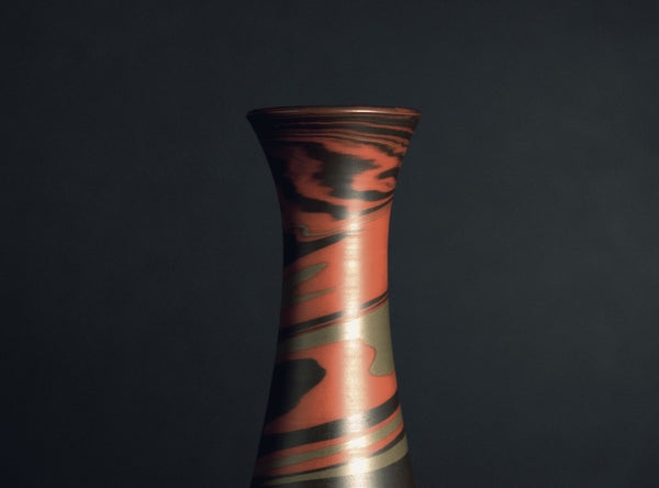 Decorative vase with swirling pattern on a black background