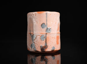 Ceramic container with textured surface on a black background