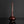 Load image into Gallery viewer, A glossy dark reddish-brown ceramic vase with a long, slender neck and a rounded base, displayed on a reflective black surface against a dark gray background.
