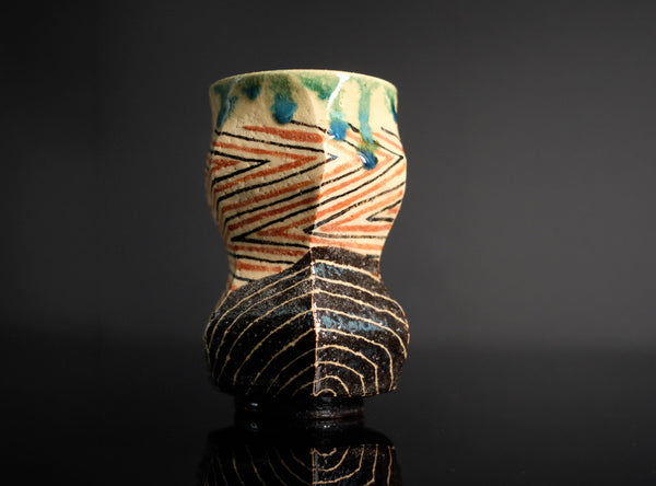 Ceramic cup with abstract patterns on a dark background