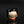 Load image into Gallery viewer, A handmade ceramic cup with a glossy black glaze, featuring a hand-painted beige and brown pattern of a city skyline and geometric shapes on the front, set against a dark reflective background.
