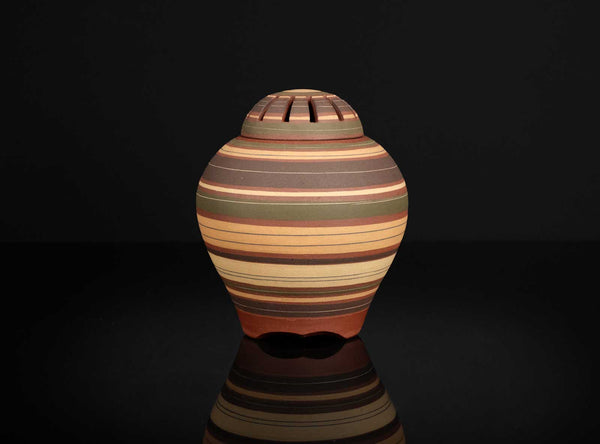Striped ceramic vase on a black background