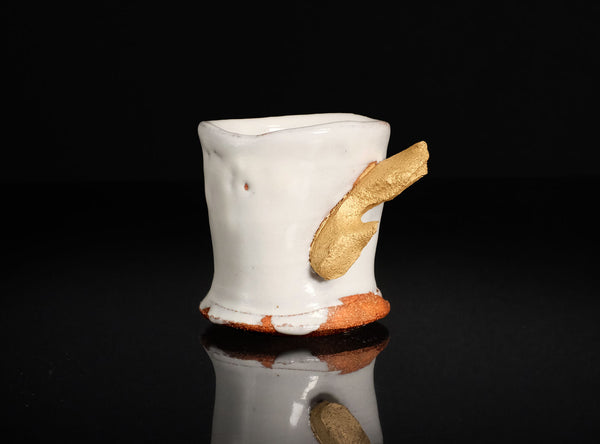 Ceramic cup with gold  branches on a black background