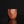 Load image into Gallery viewer, A handmade terracotta ceramic bizen guinomi with a faceted, geometric design and a carved kanji character, displayed on a reflective black surface against a solid black background.
