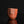 Load image into Gallery viewer, A handmade terracotta ceramic bizen guinomi with a faceted, geometric design and a carved kanji character, displayed on a reflective black surface against a solid black background.
