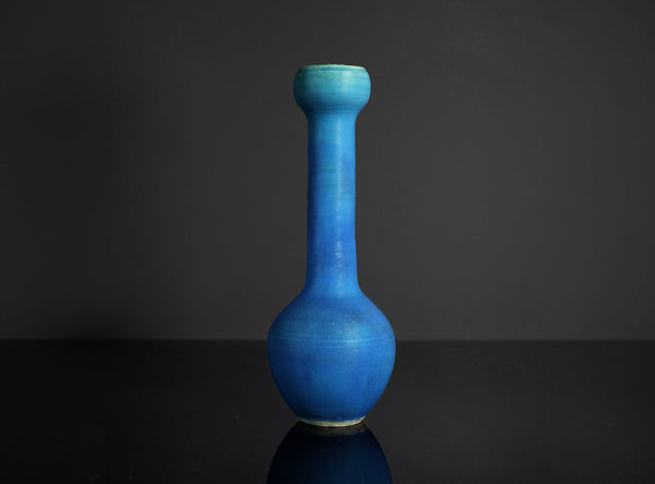 Blue vase on a dark surface with a dark background