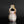 Load image into Gallery viewer, A small handmade ceramic vase with a unique organic shape, featuring a pink and white glaze with brown and gold accents, set against a dark gray background with a reflective black surface.
