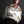 將圖片載入到圖庫檢視器中， A small ceramic bottle with a rounded body, narrow neck, and flared rim, featuring a glossy glaze with marbled white, brown, and reddish tones, set against a dark reflective background.
