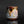 Load image into Gallery viewer, A handmade ceramic cup with a dripping glaze finish, featuring a mix of brown, gold, pink, and gray colors, set against a dark reflective background.
