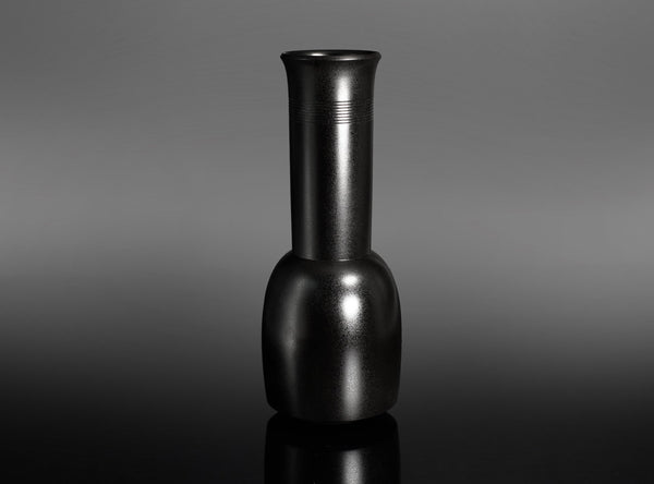 A Bronze Kinuta Flower Vase with a flared cylindrical neck and a rounded base, standing on a reflective black surface against a gray gradient background.
