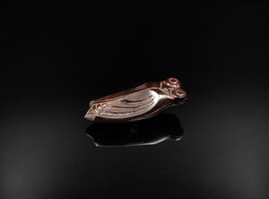 A finely cast bronze kōgō in the form of a cicada, shown on a glossy black reflective surface against a black background.
