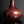 Load image into Gallery viewer, A glossy reddish-brown ceramic vase with a bulbous rounded body and a narrow neck, photographed on a dark reflective surface against a dark gray background.
