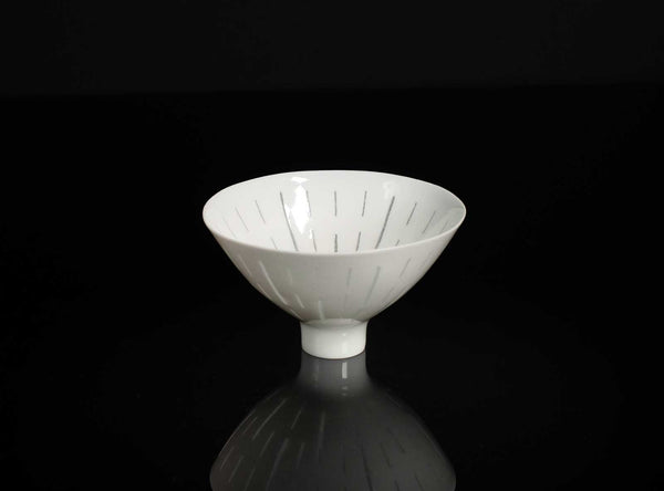 White ceramic cup with textured interior on a black background