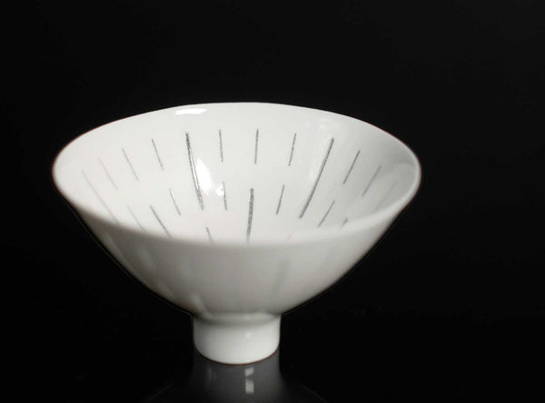 White ceramic cup with textured surface on a black background