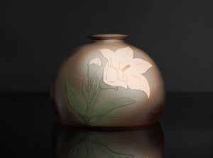 Ceramic vase with floral design on a dark background