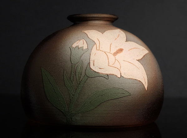 Ceramic vase with floral design on a dark background