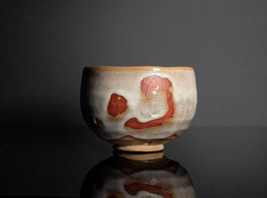 Ceramic bowl with artistic design on a reflective surface