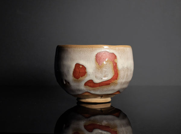 Ceramic bowl with artistic design on a reflective surface