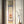 Load image into Gallery viewer, A vertical Japanese-style hanging scroll artwork displayed in a narrow frame, featuring a samurai warrior illustration. The scroll hangs against a light wall next to a vase with dried branches.
