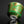 Load image into Gallery viewer, Decorative ceramic cup with green and gold patterns on a reflective surface.

