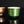 Load image into Gallery viewer, Two ornate cups, one red and gold, the other green and gold, on a reflective black surface.
