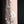 Load image into Gallery viewer, A close-up of a cylindrical product with a textured, cracked surface showing white and light gray sections over a warm peach-pink base, set against a solid black background.
