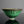將圖片載入到圖庫檢視器中， A green glazed ceramic bowl with a dark metallic drip pattern around the rim, set against a dark gray background with a reflective surface below.
