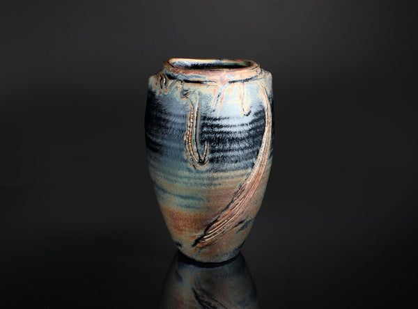 Stoneware vase with textured surface on a dark background