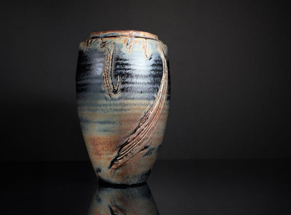 Ceramic vase with textured surface on a dark background